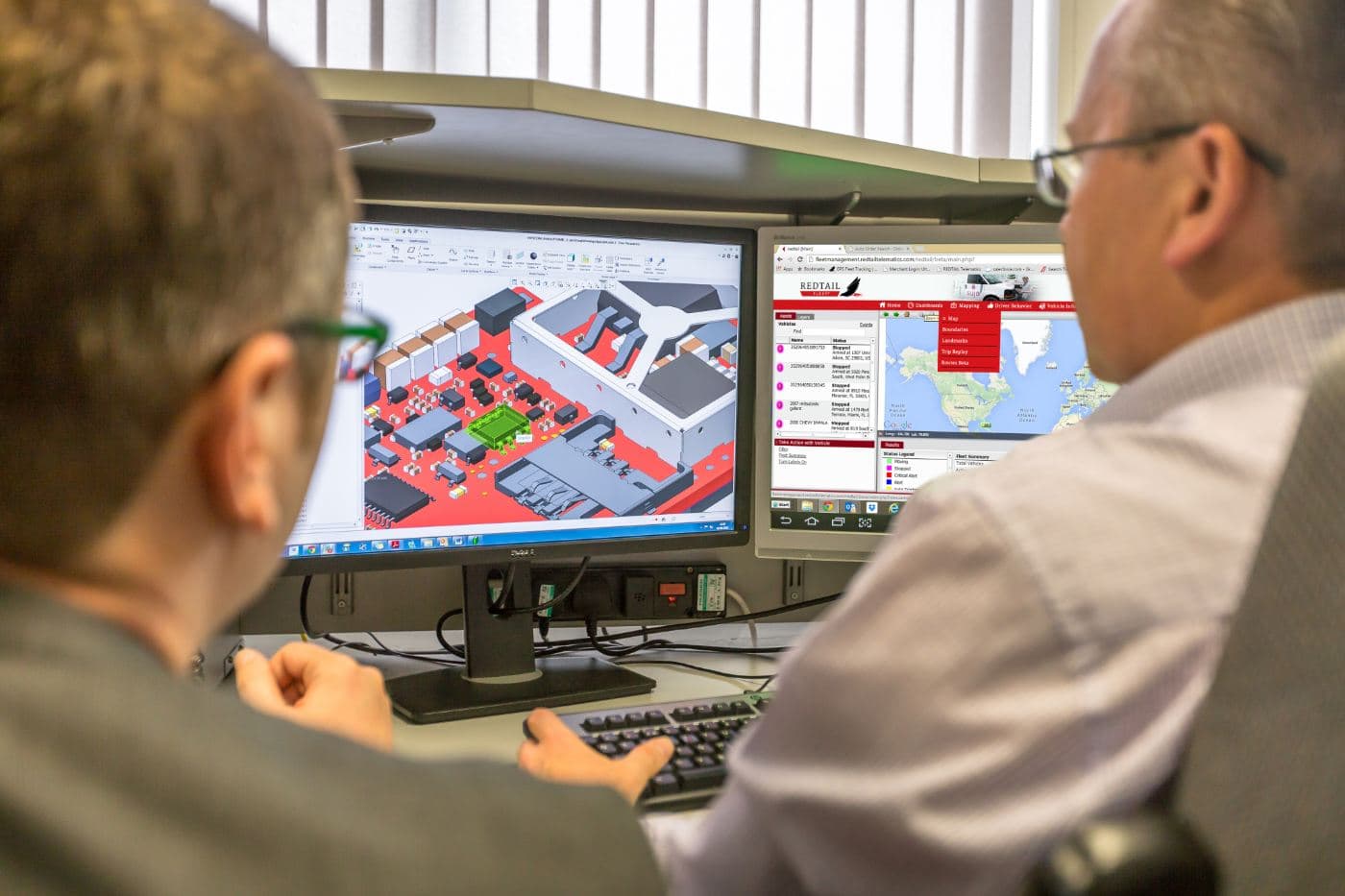 Redtail engineers examining hardware design alongside the telematics portal